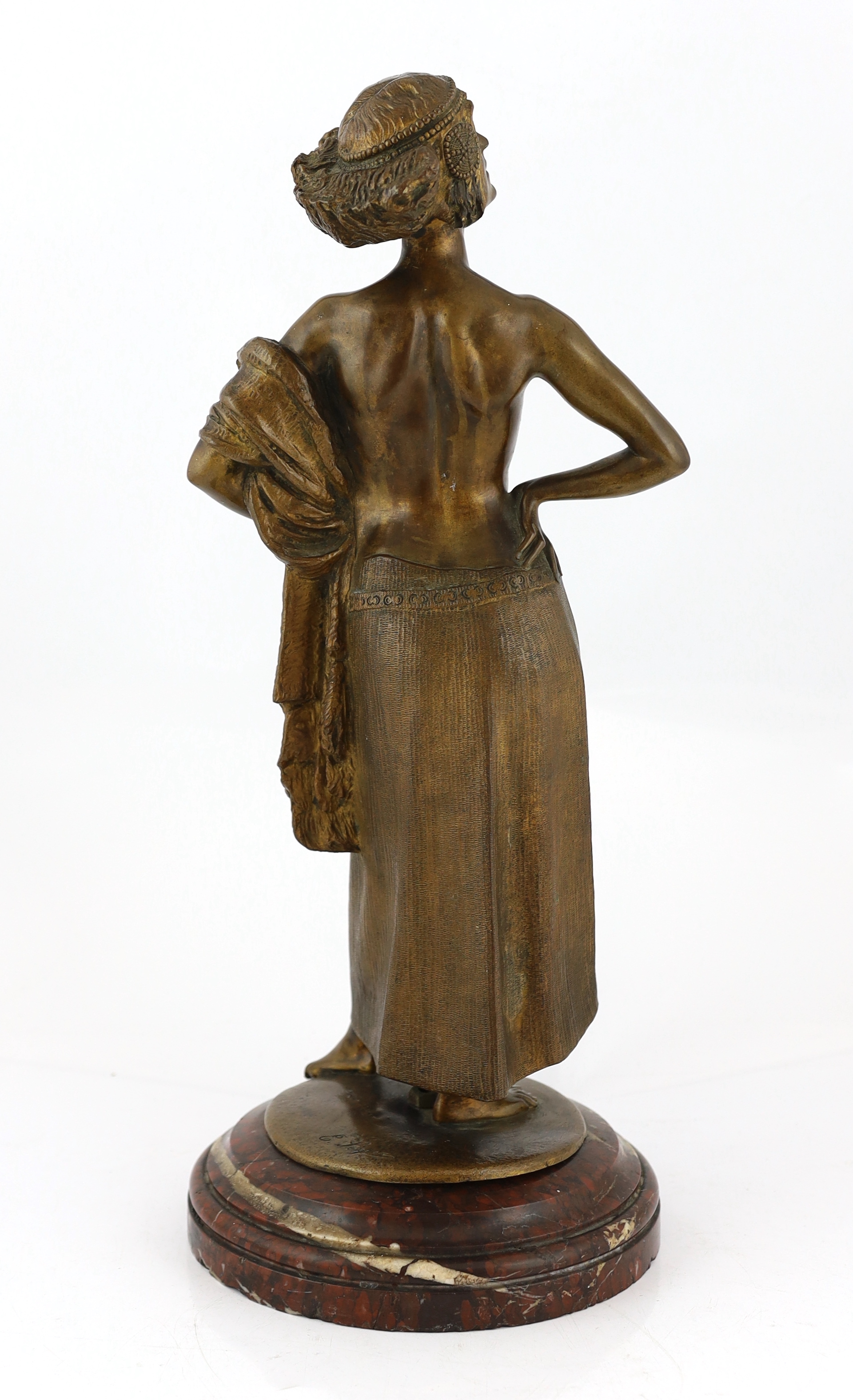 E. Leger - a bronze figure of an Eastern dancer standing with her hands on her hips, signed in the bronze, on rouge marble socle, 53cm high